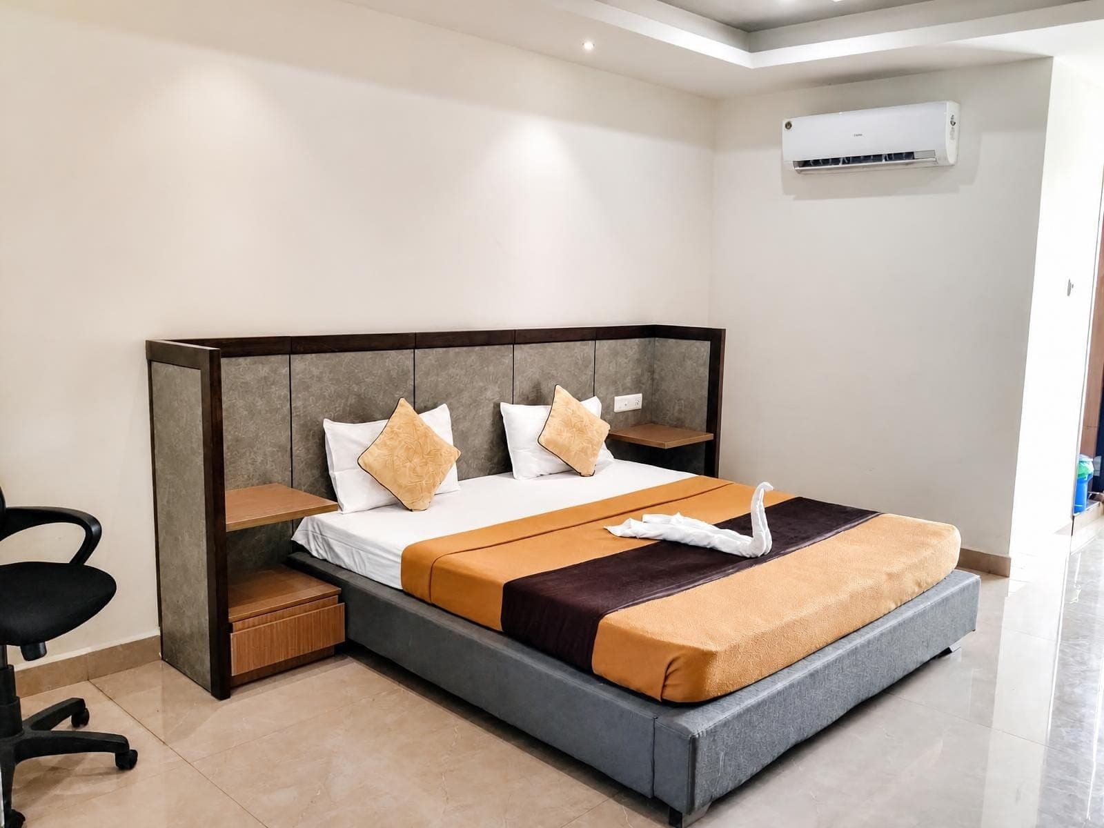 Deluxe A/C room with a double bed, split air conditioner and a work chair
